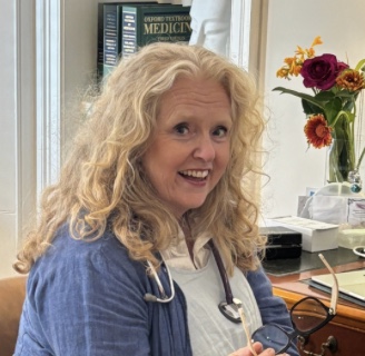 Dr Veronica McBurnie sitting at her desk smiling
